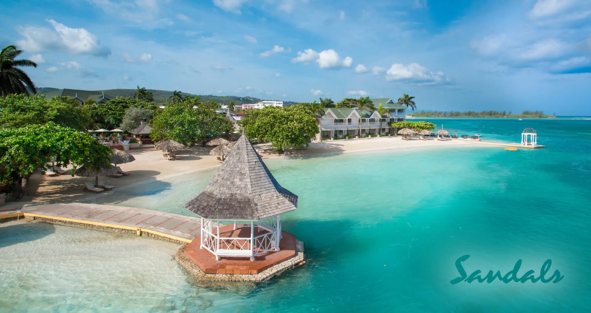 Enveloped in the shade of palm trees, a white gazebo complements the crystalline blue water and pristine sand, illustrating the tranquil beauty of Royal Caribbean's private beach locations_